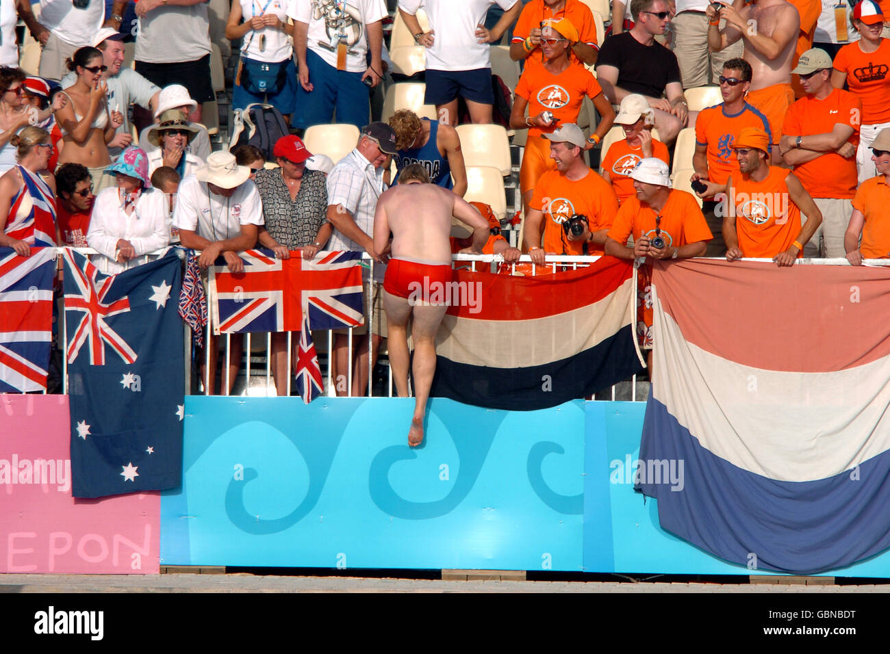 Rowing - Athens Olympic Games 2004 - Women's Double Sculls - Final. A Holland fan climbs back over the fence after swimming out to congratulate his countrys medal winners Stock Photo