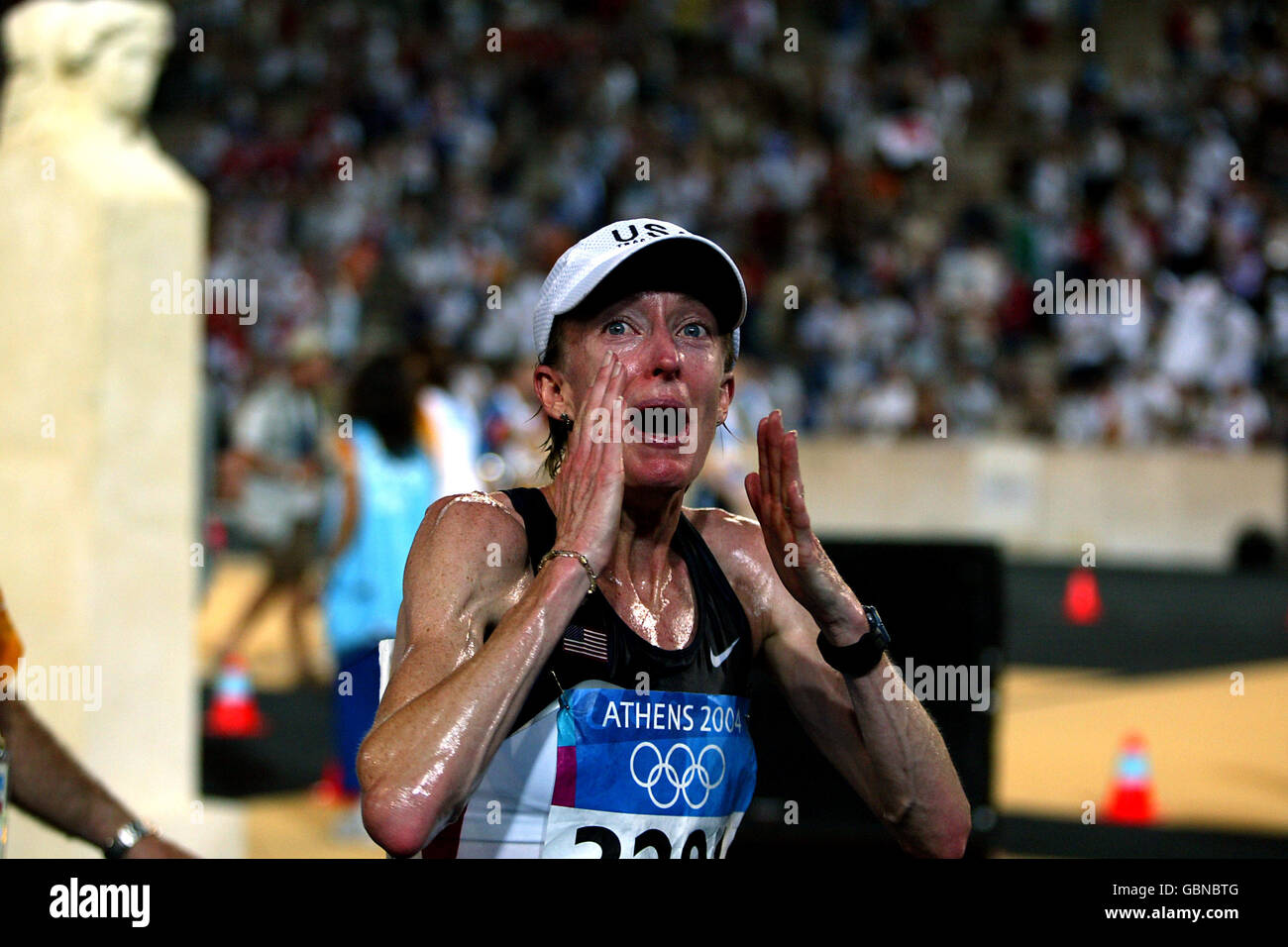 Athletics - Athens Olympic Games 2004 - Women's Marathon. USA's Deena Kastor is over whelmed as she crosses the finish line to win the bronze medal Stock Photo