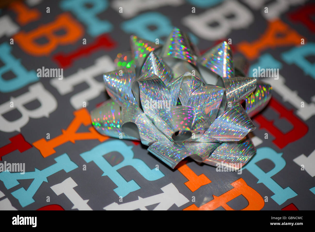 A shiny bow on birthday wrapping paper Stock Photo Alamy