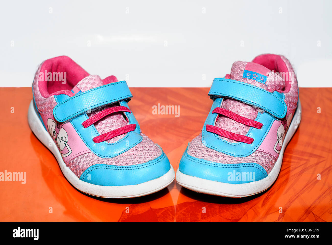 Children sport shoes isolated on gray and orange background Stock Photo