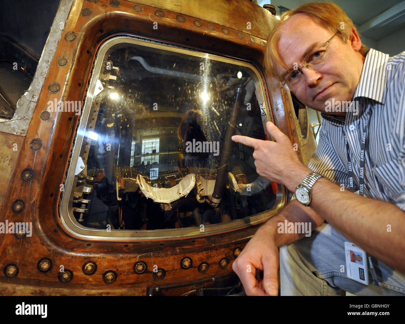 Doug Millard, senior space curator of the Science Museum in London, looks inside the Apollo 10 command module through the perspex cover which will be removed on Saturday May 23 so the public can see close inside for the first time. Stock Photo