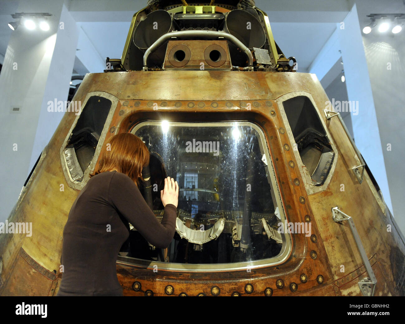 A staff member at the Science Museum in London, looks inside the Apollo 10 command module through the perspex cover which will be removed on Saturday May 23 so the public can see close inside for the first time. Stock Photo