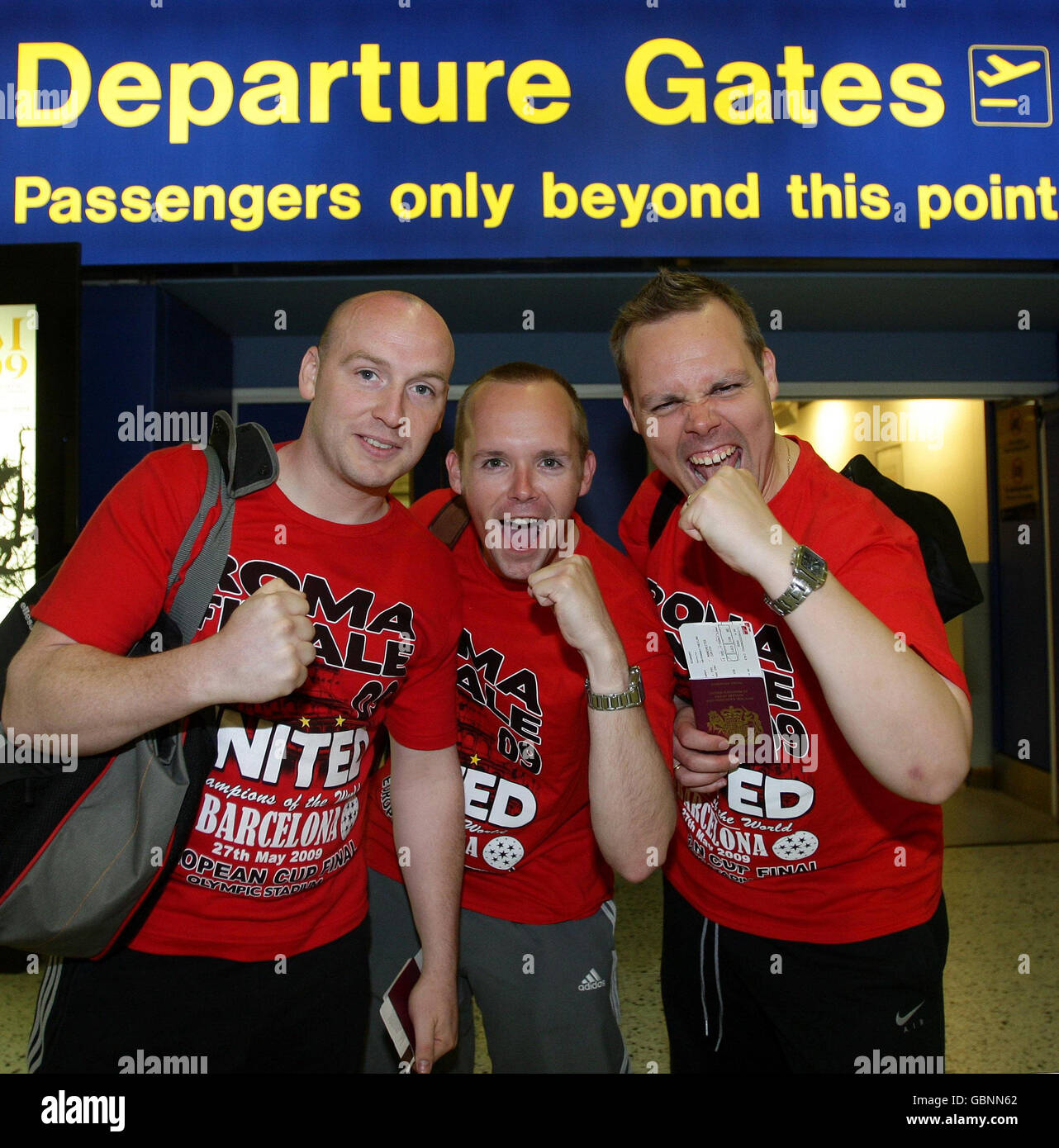 Manchester United fans Christopher Dunn (left), Mike and Neil Hathaway (right) at Manchester Airport prior to flying out to Rome for the UEFA Champions League Final. Stock Photo