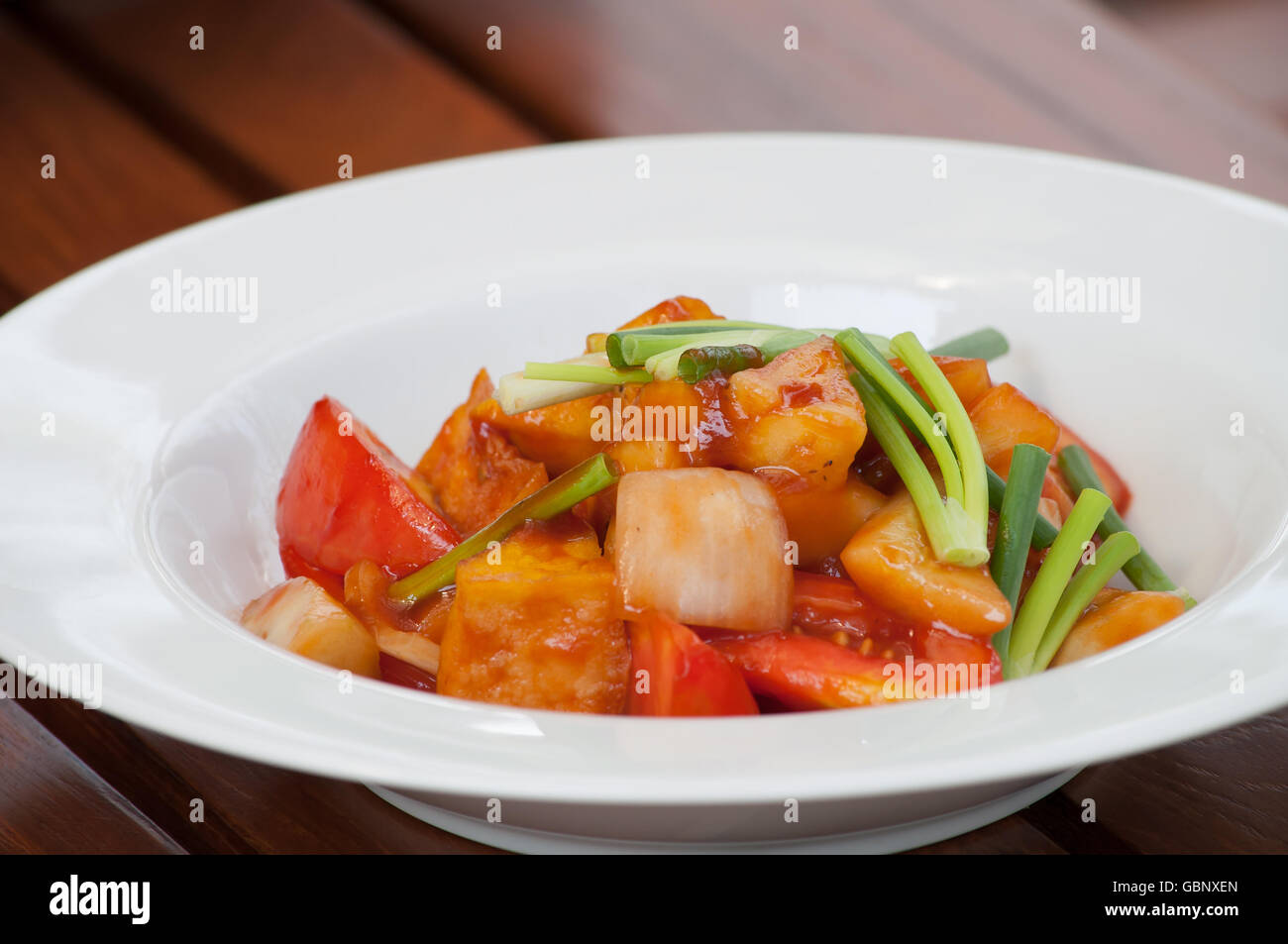 Deep Fried yellow Bean Curd with Sweet and Sour Sauce in a white dish