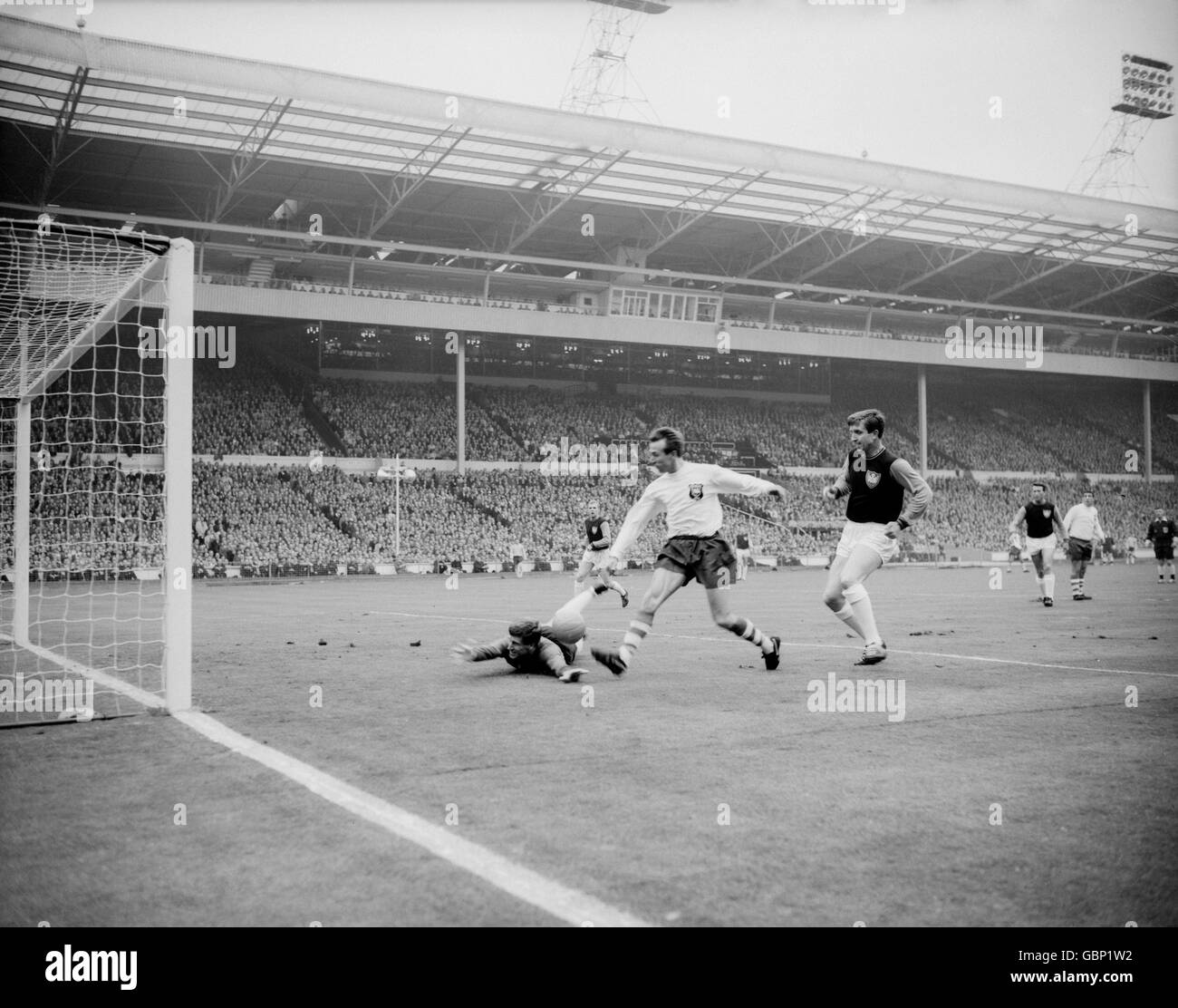Preston North End's Doug Holden (c) beats West Ham United's Jim Standen (l) and John Bond (r) to score the opening goal Stock Photo