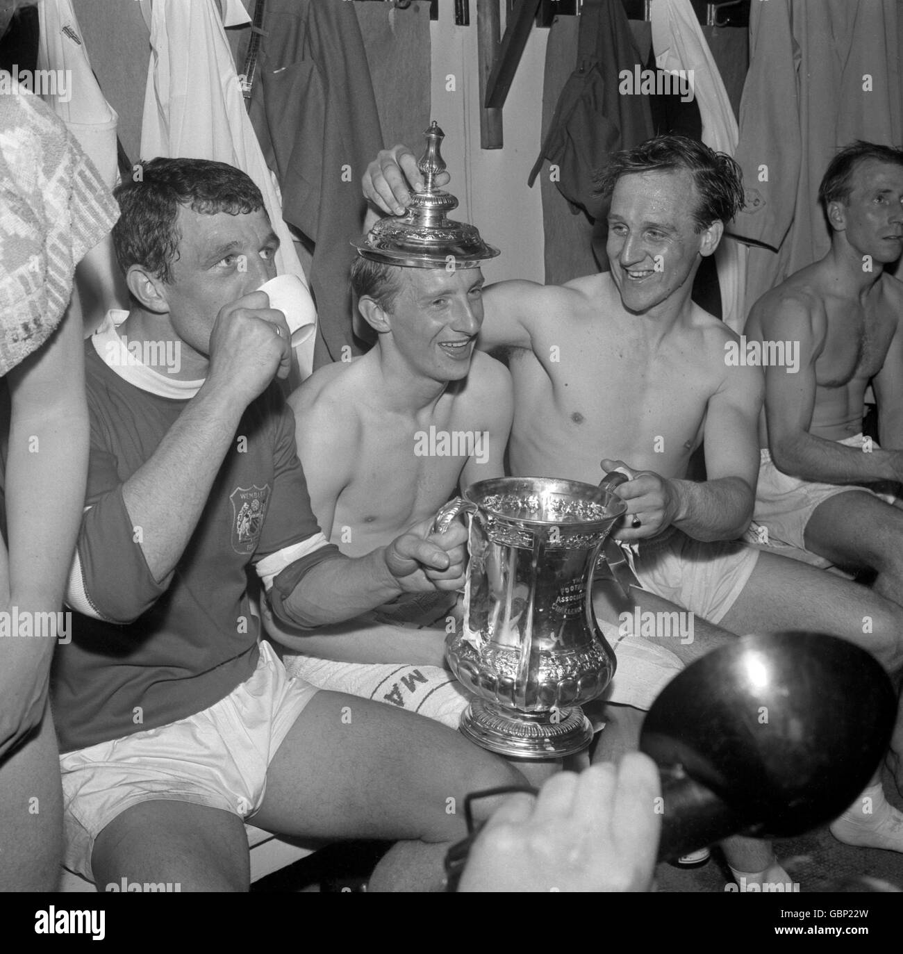 (L-R) Manchester United's David Herd, Denis Law and Maurice Setters celebrate with the FA Cup in the changing room after their 3-1 victory. Stock Photo