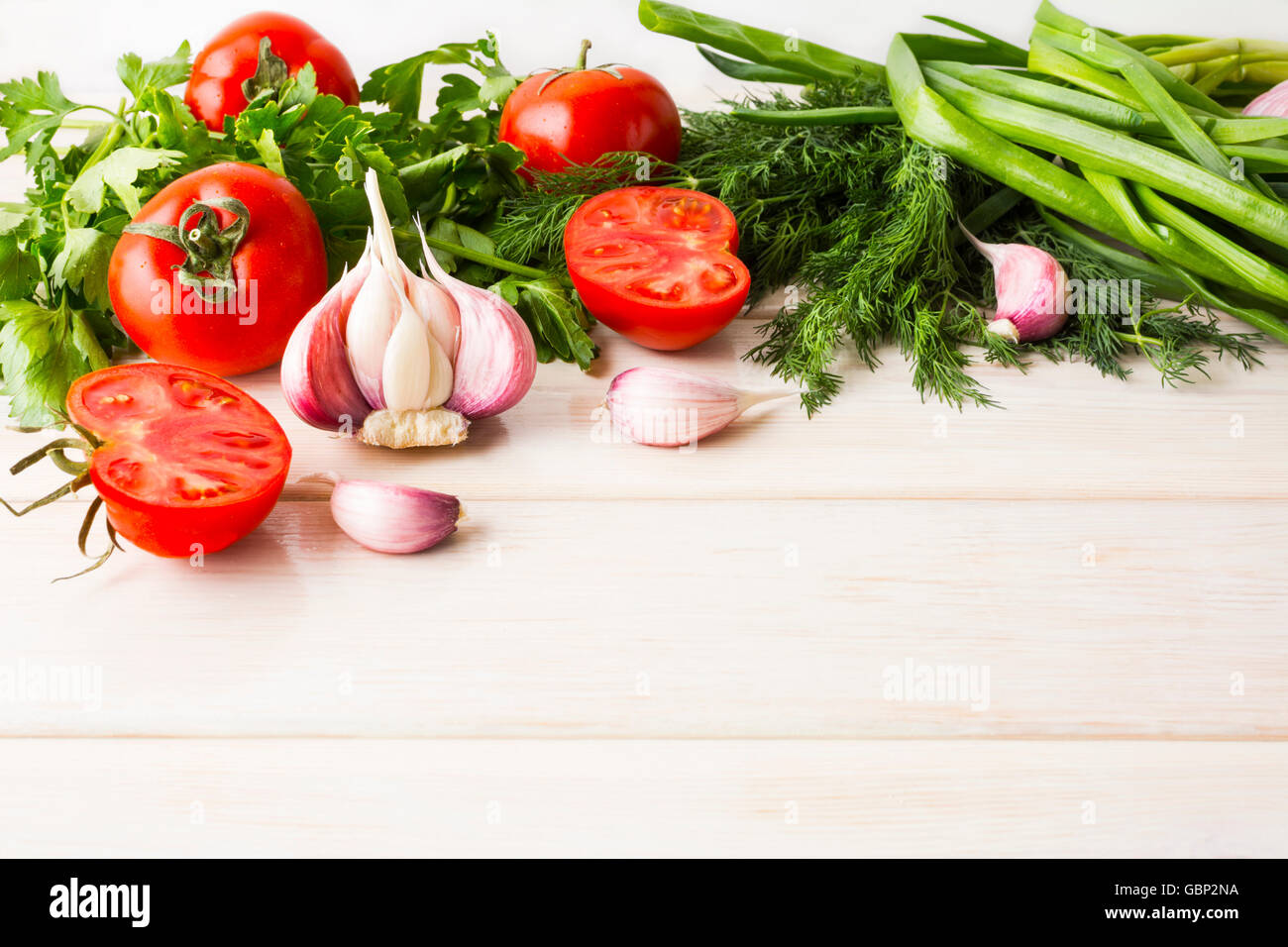 Garlic and tomato on the white wooden background. Vegetarian  vegan food. Healthy eating concept with fresh vegetables. Stock Photo