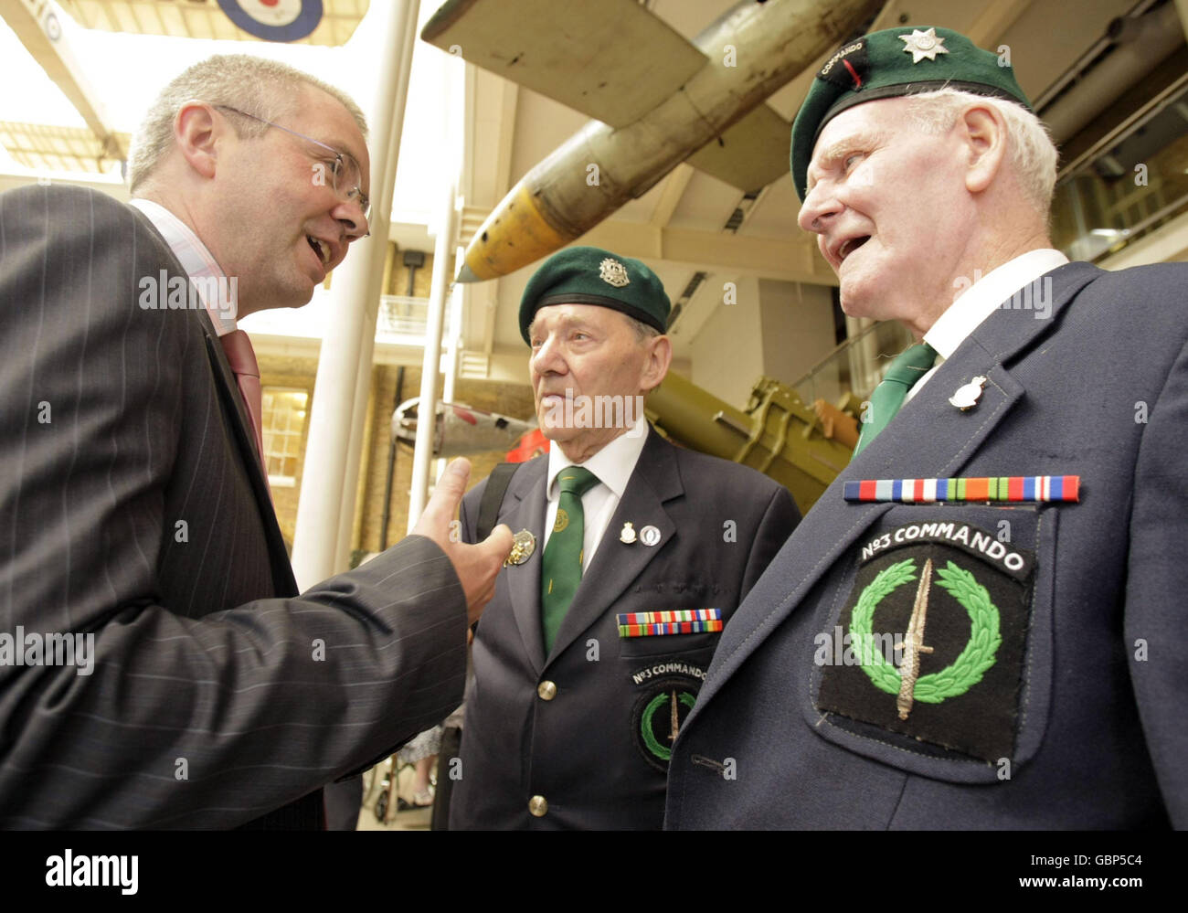 Peter Wanless (left), CEO of the Big Lottery Fund, talks with WWII veterans Fred Walker (centre) and Jim Clinton, both of No3 Commando, at The Imperial War Museum, London, as they announced that they are to return to the scene of the D-Day landings. Stock Photo