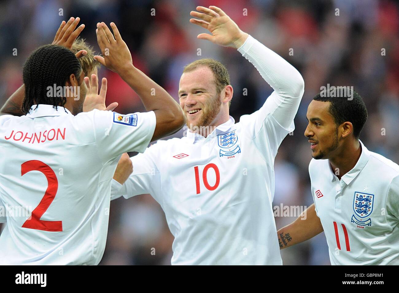 England's Wayne Rooney (centre) celebrates scoring his sides first goal with teammates Theo Walcott (right) and Glen Johnson (left) Stock Photo
