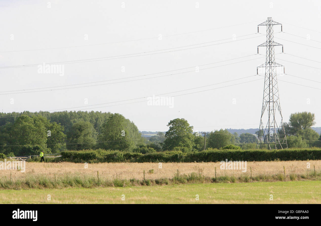 Police patrol fields in Sutton Courtenay, near Abingdon in Oxfordshire, where two people were today killed in a mid-air crash today when their RAF training aircraft collided with a glider. Stock Photo