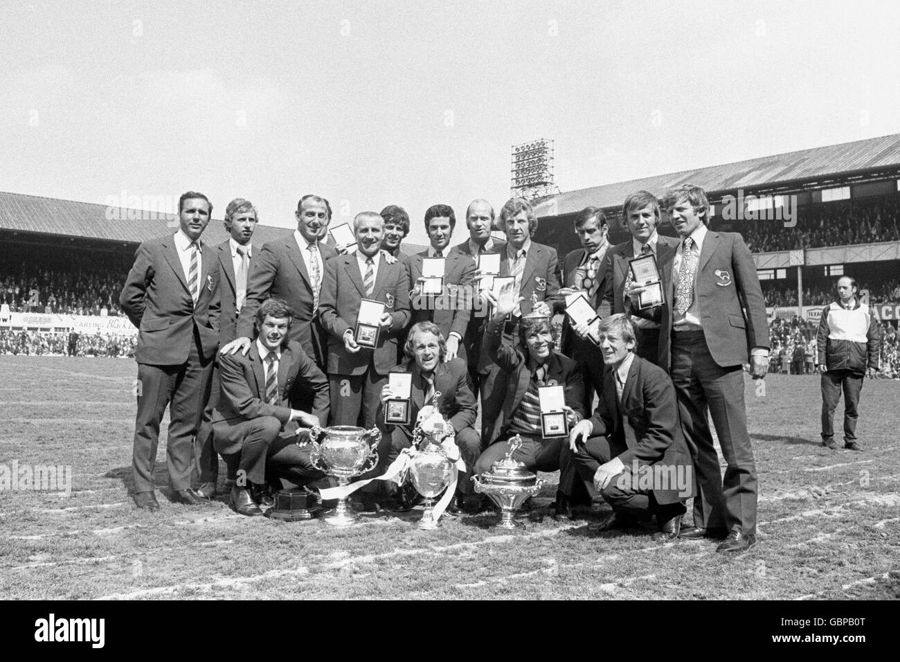 Derby County players show off their League Championship medals aas they pose with the trophies won by the club during the 1971-72 season: (back row, l-r) ?, John McGovern, physio Gordon Guthrie, trainer Jimmy Gordon, Ron Webster, John Robson, Terry Hennessey, Alan Hinton, John O'Hare, Colin Boulton, Alan Durban; (front row, l-r) Peter Daniel, Archie Gemmill, Kevin Hector, ?; (trophies, l-r) Central League, Football League Championship, Texaco Cup Stock Photo