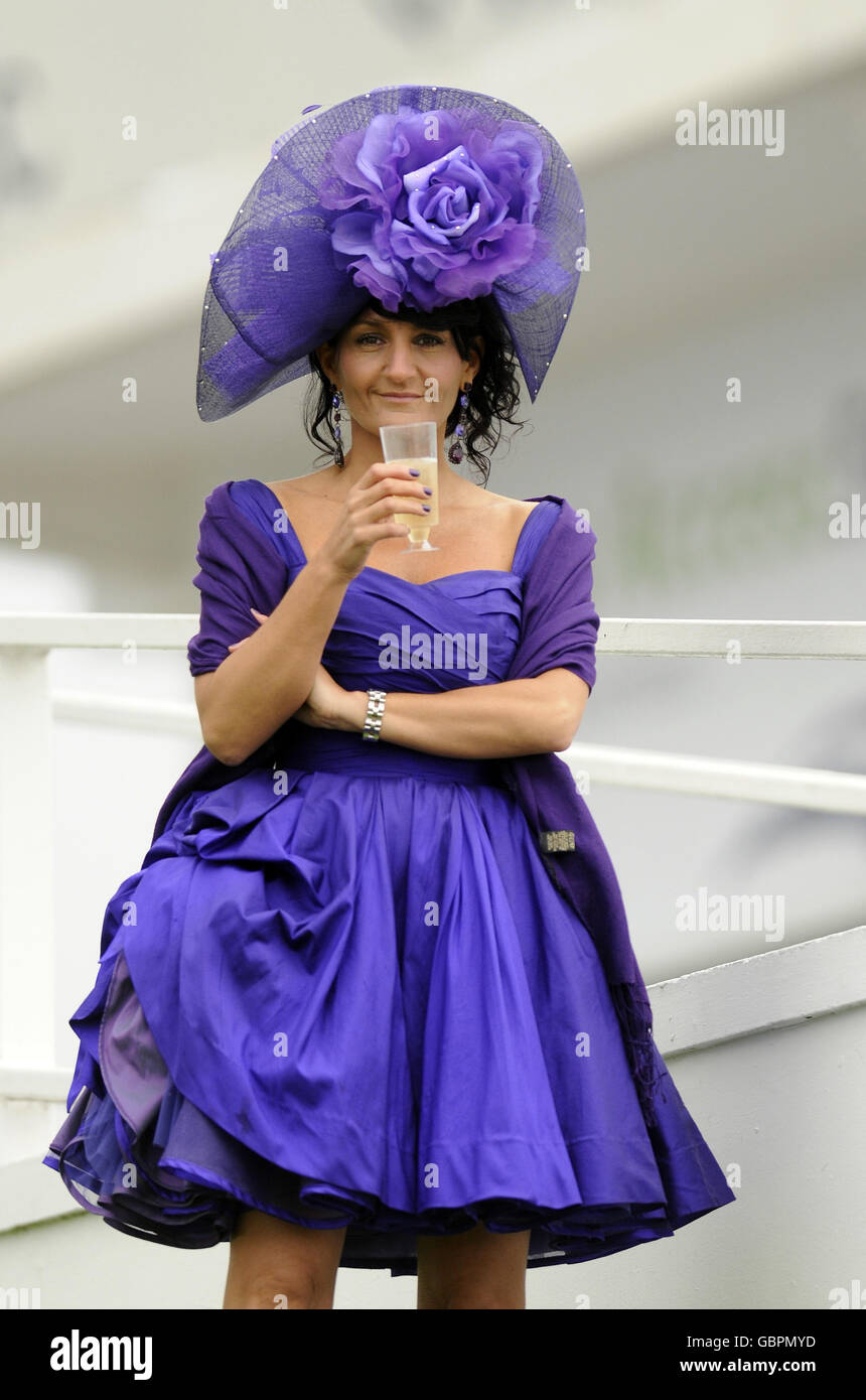 A racegoer enjoys some refreshment during The Investec Ladies Day at Epsom Racecourse, London. Stock Photo