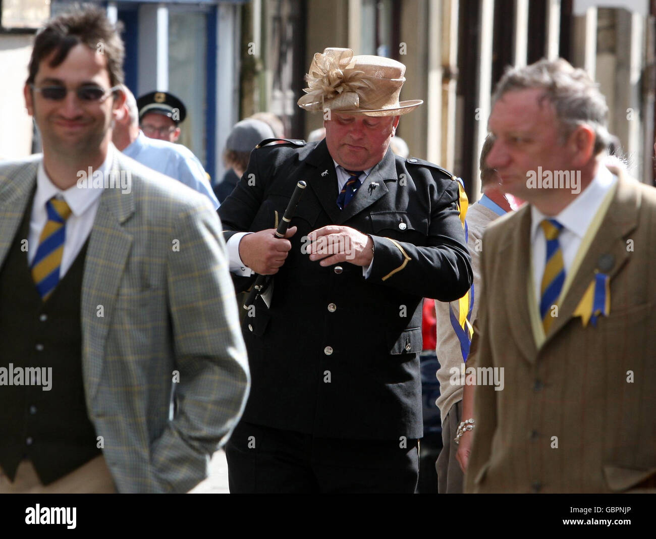 A member of the Hawick Fifes and Drums band gets into the party spirit by wearing a woman's hat