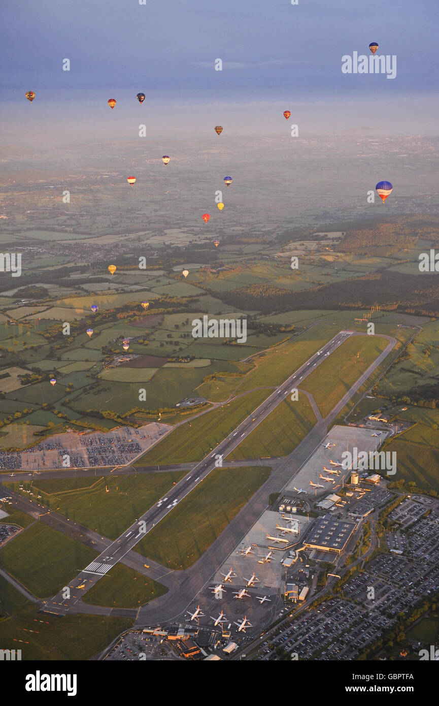 Hot air balloons lift off from the main runway at Bristol International Airport for the first time in the airport's history and fly over the South West in the early morning sun. Stock Photo