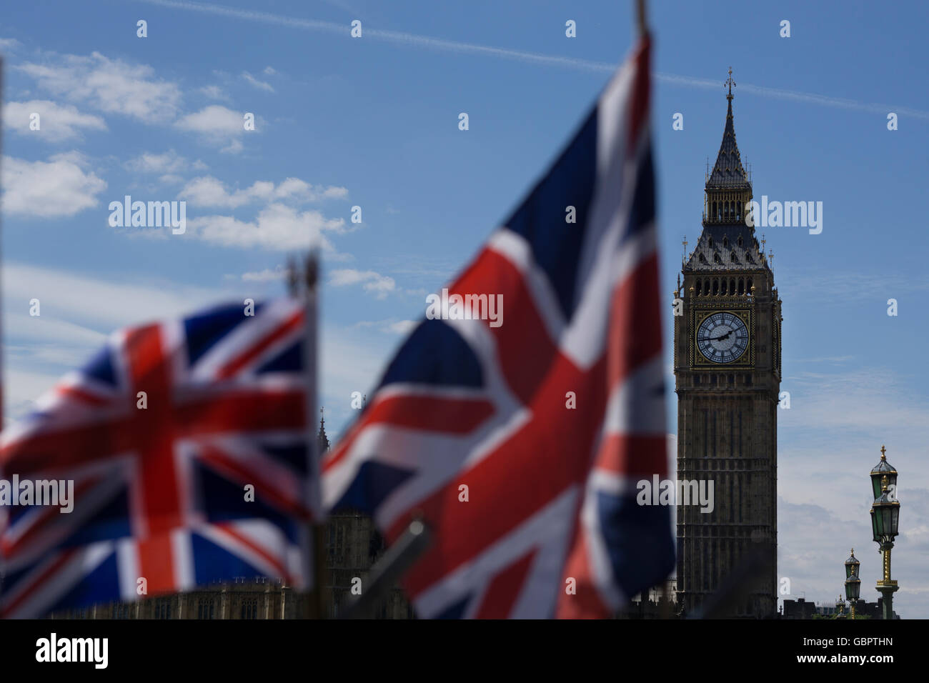 Famous London landmark of Big Ben prominent in the background behind two British Union Jack Flags Stock Photo