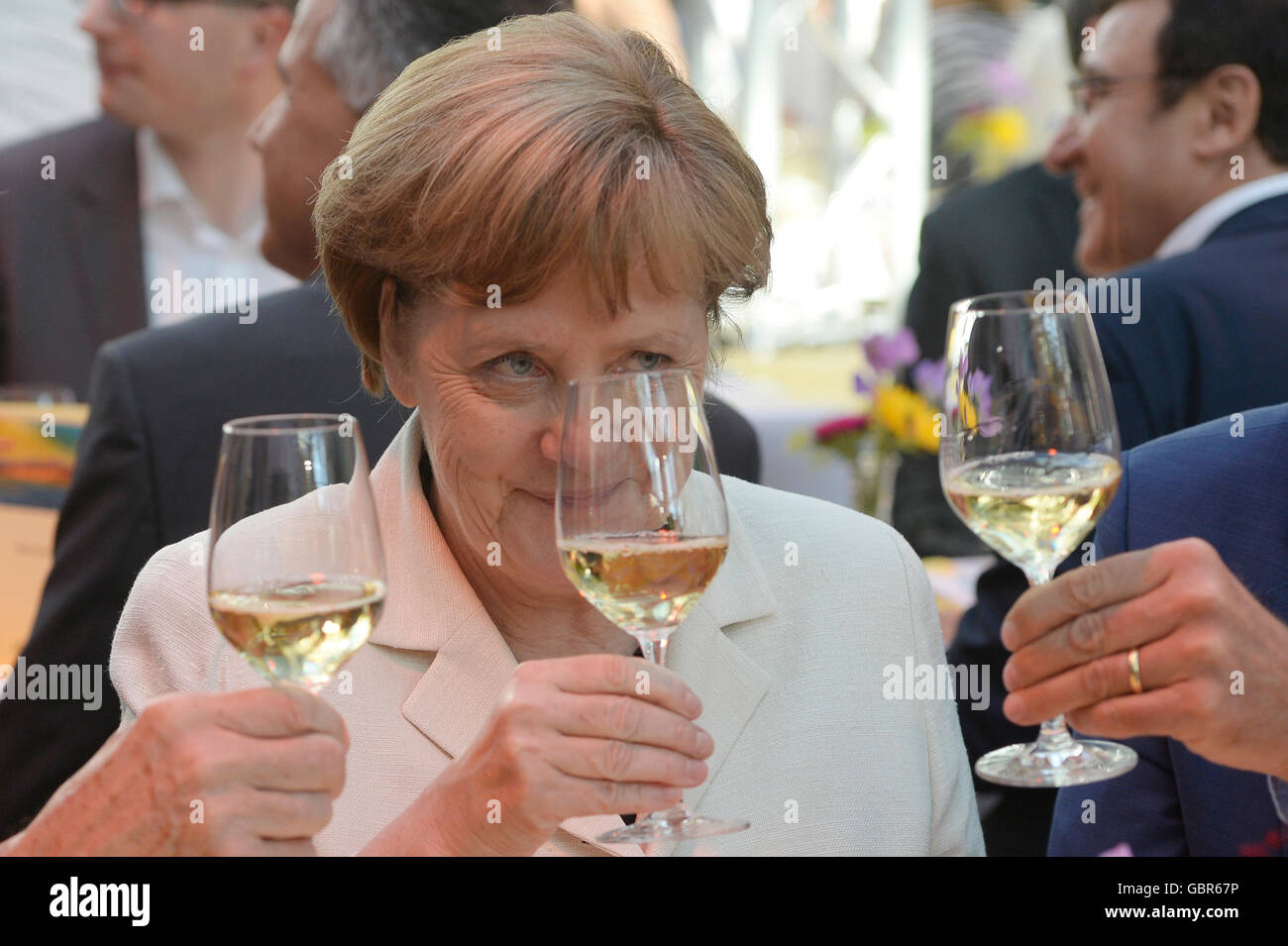 German Chancellor Angela Merkel (CDU) pictured at the Stallwaechterparty of the Baden-Wuerrtemberg state representation, holding a glass of wine, in Berlin, Germany, 7 July 2016. The party traditionally takes place at the start of the parliamentary summer break. PHOTO: MAURIZIO GAMBARINI/DPA Stock Photo