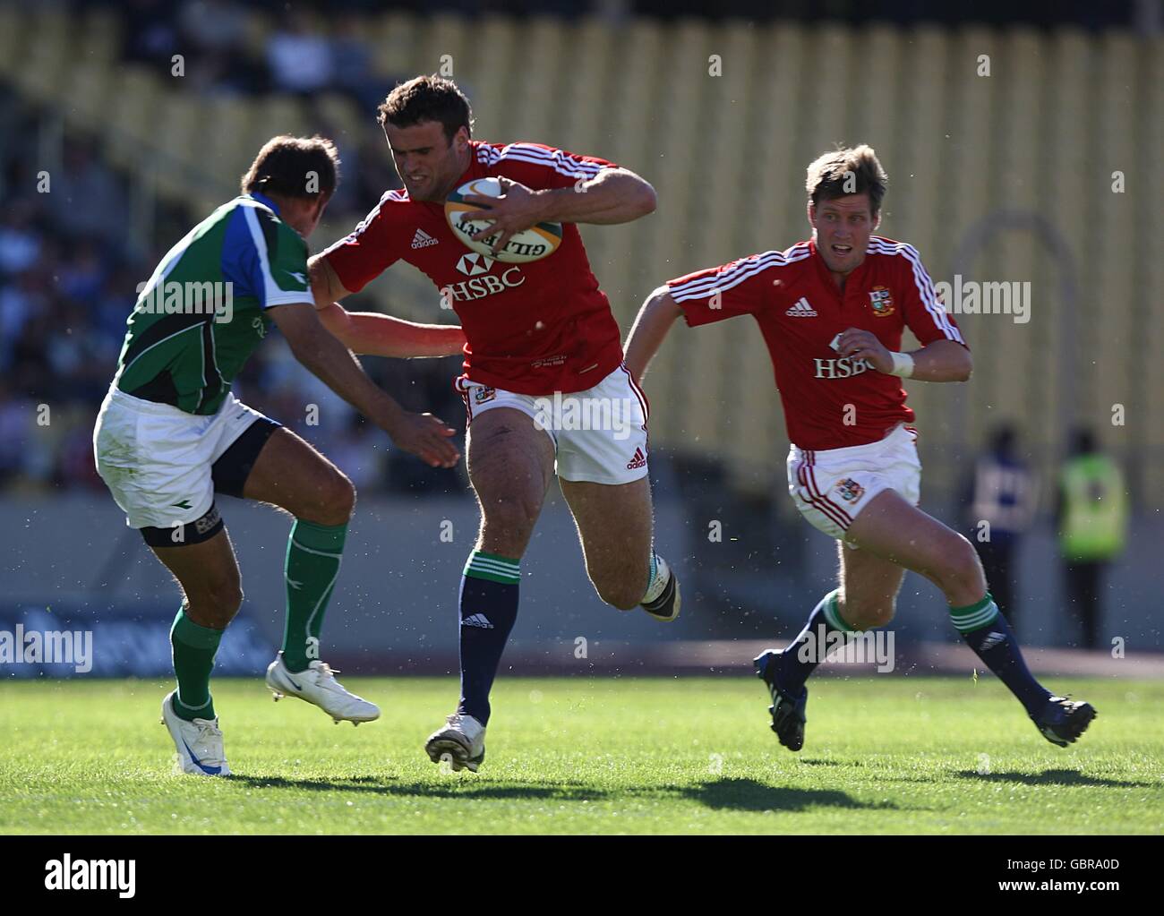 British and Irish Lions' Ronan O'Gara (right) looks on as teammate Jamie Roberts (centre) powers past Royal Highveld XV's Naas Olivier (left) Stock Photo