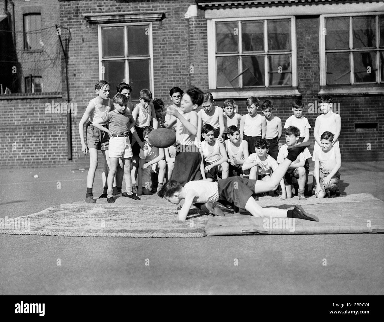 Boys at the Bacon School, Bermondsey, practice rugby tackling in the