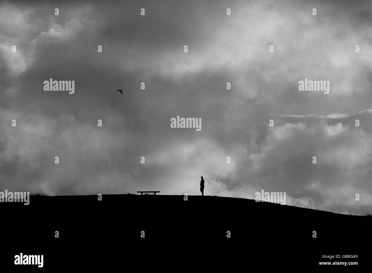 Lone silhouette figure against stormy sky Crescent Head NSW Australia Stock Photo
