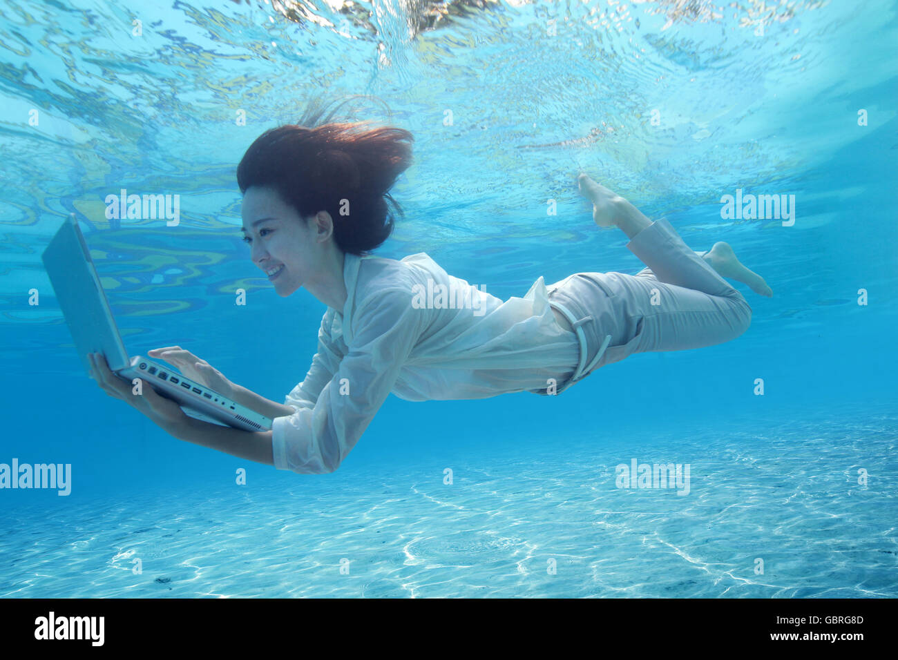 Young women use computers in underwater Stock Photo Alamy