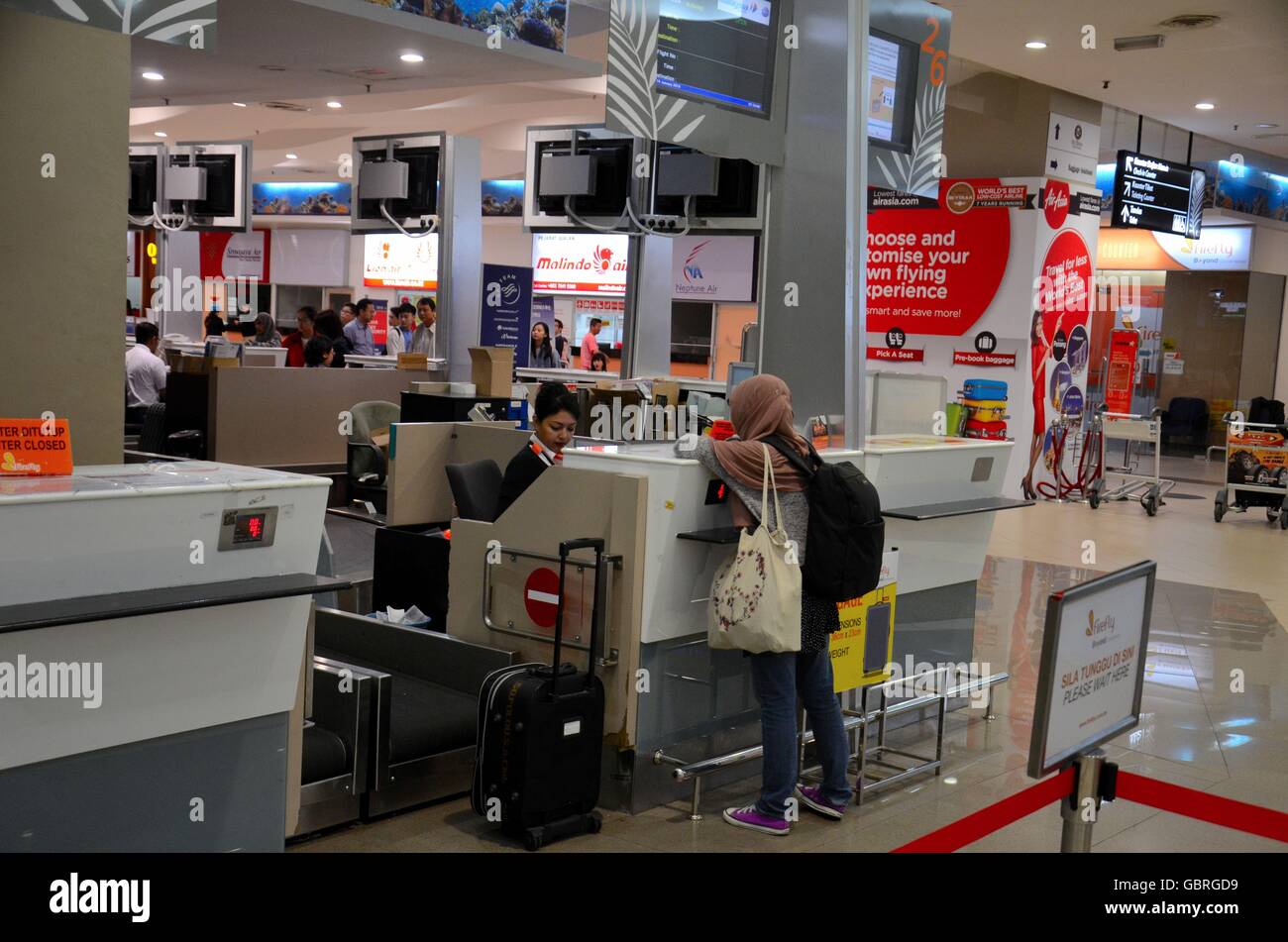 Malay female passenger checks in for Fire Fly flight Penang