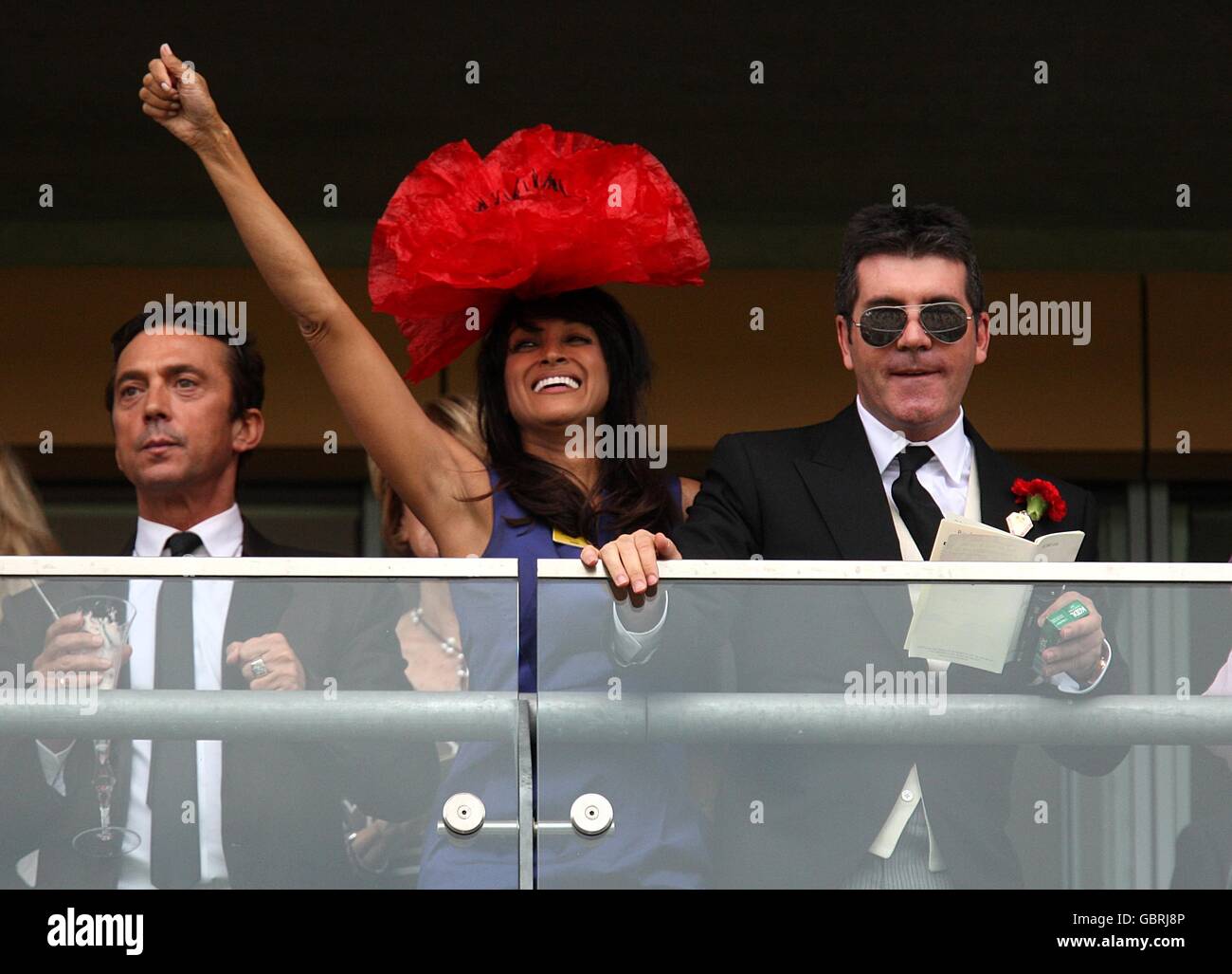 Bruno Tonioli, Jackie St. Clair and Simon Cowell cheers on the riders in the Royal Hunt Cup Heritage Handicap from the stands with Bruno Tonioli (left) and Jackie St Clair at Ascot Racecourse, Berkshire Stock Photo