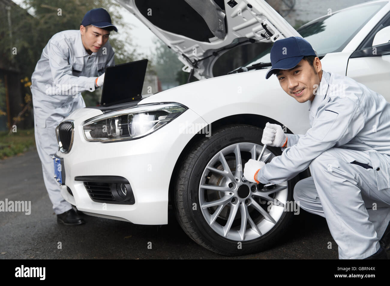 Auto repair personnel in the maintenance of automobile Stock Photo - Alamy