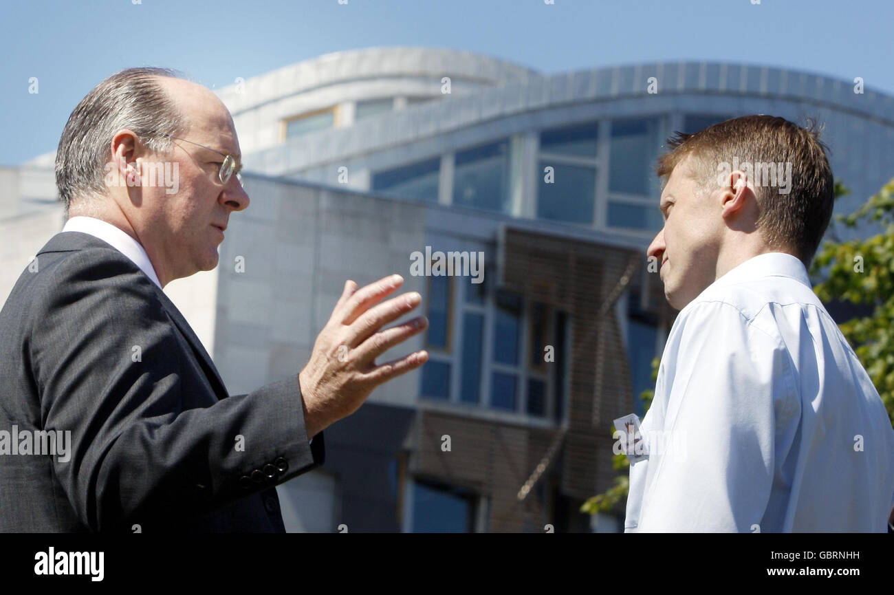 Finance secretary John Swinney (left) talks to Stop Climate Chaos campaigner Mike Robinson outside the Scottish Parliament in Edinburgh, following a decision by MSP to back a higher target for cutting greenhouse gas. Stock Photo