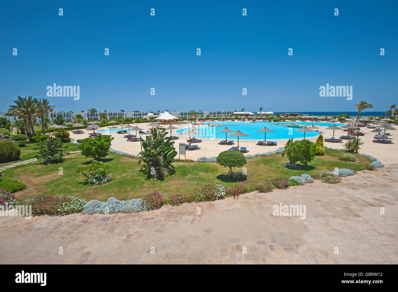 Aerial view over swimming pool and gardens of large luxury tropical ...