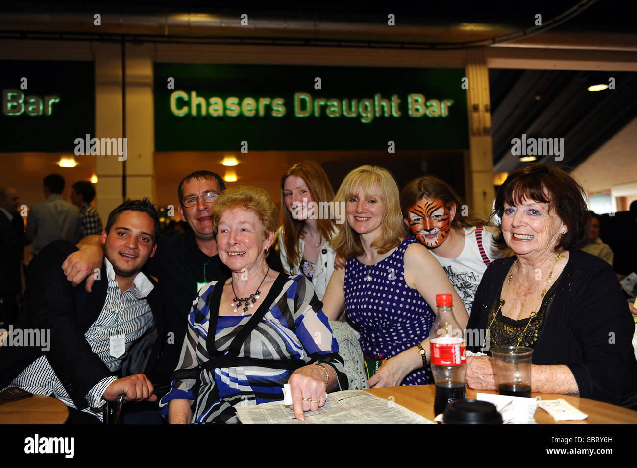 Racegoers enjoy a drink at the Chasers Draught Bar during Irish Day at Sandown Park. Stock Photo