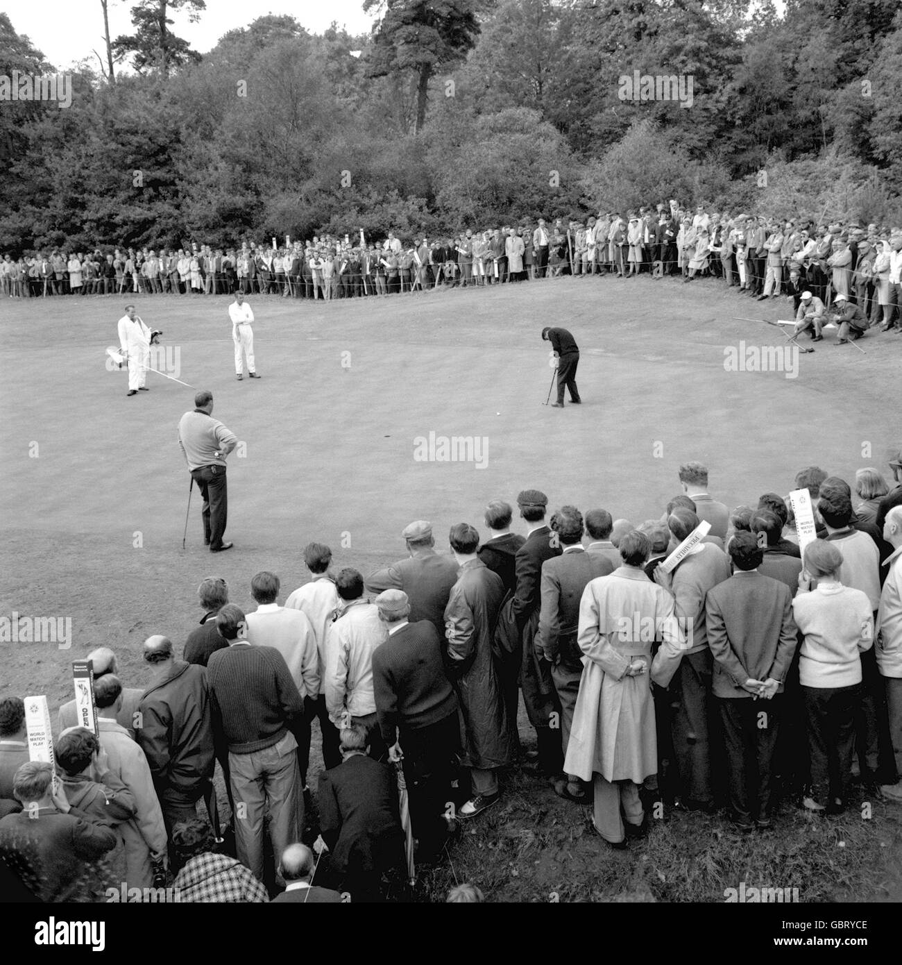 Arnold Palmer (l) looks on as Gary Player (r) putts on the 16th green during their semi final match Stock Photo