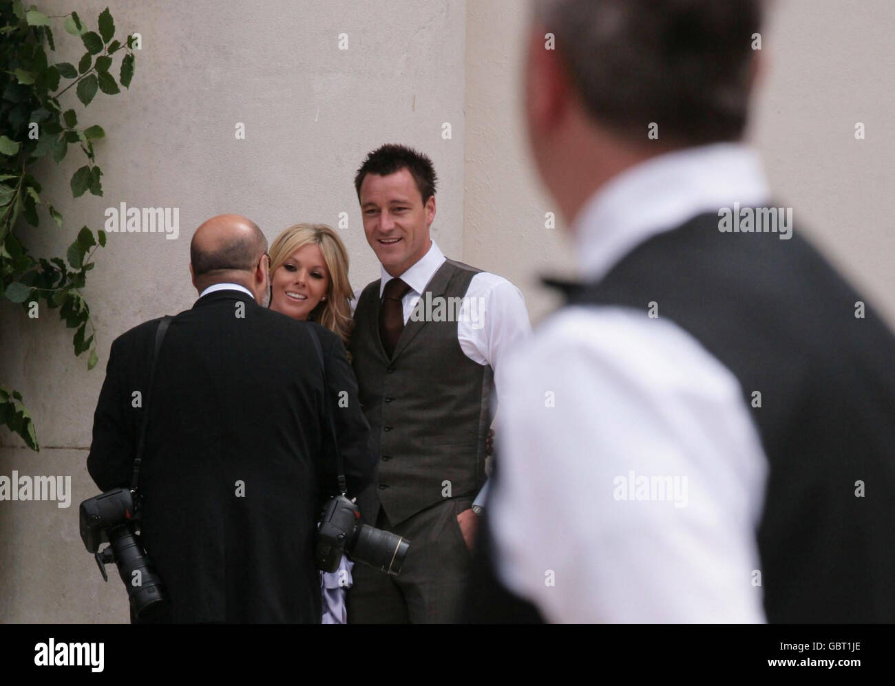 John Terry and wife Toni pose for photographer Richard Young outside the Royal Hospital where England and Chelsea FC footballer Joe Cole and Carly Zucker are due to get married today. Stock Photo