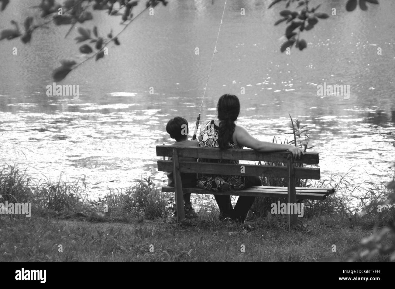 child fishing and his mother at Greenbelt Lake, in Greenbelt, Maryland Stock Photo