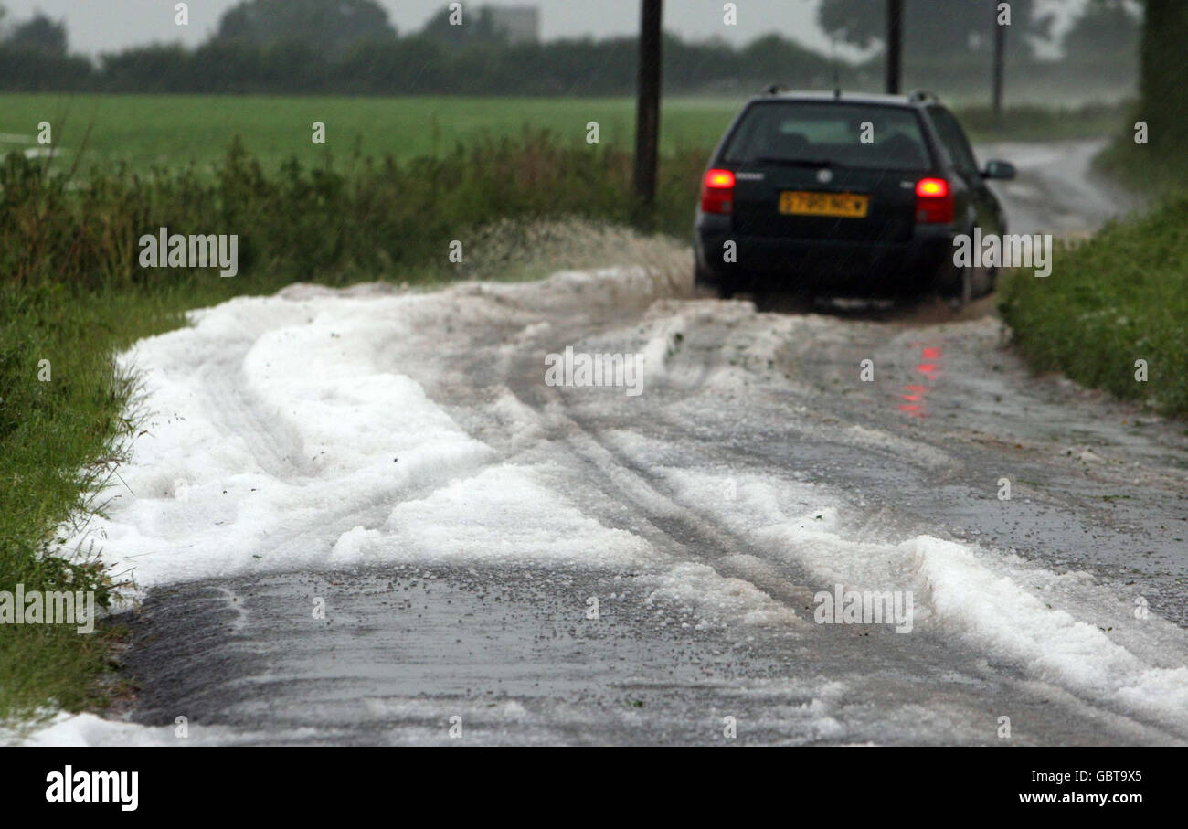Warm weather. Hail stones on a road at Watton, Norfolk, as thunderstorms cause flash flooding in the area. Stock Photo