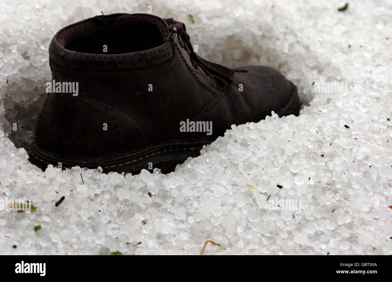 A Dr Martin Boot rests in hail stones following a storm at Watton, Norfolk. Stock Photo