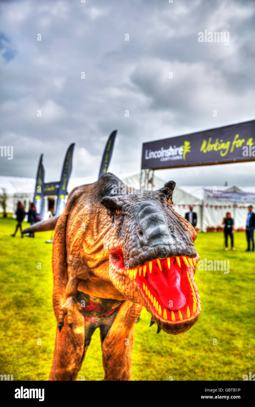 Velociraptor prehistoric dinosaur Jurassic park costume with man inside scaring people UK England GB Stock Photo