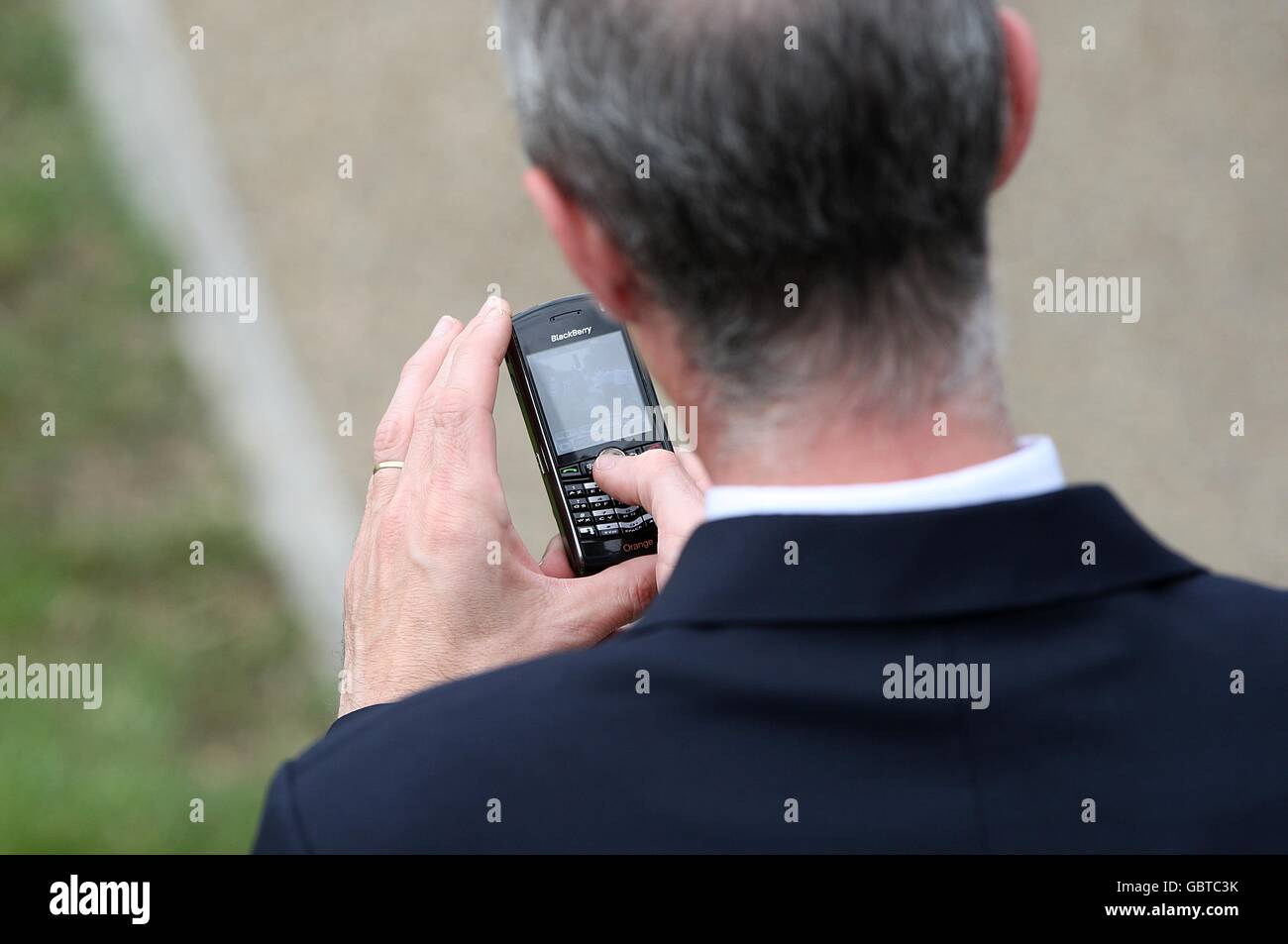 Horse Racing - The Royal Ascot Meeting 2009 - Day Two - Ascot Racecourse. A racegoer sends a text message on his mobile phone at Ascot Racecourse, Berkshire Stock Photo