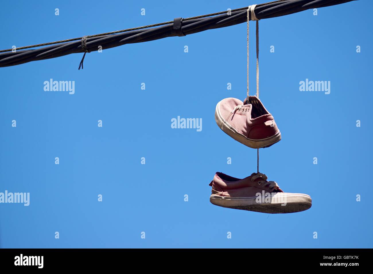 Old sneakers hanging from a cable Stock Photo Alamy