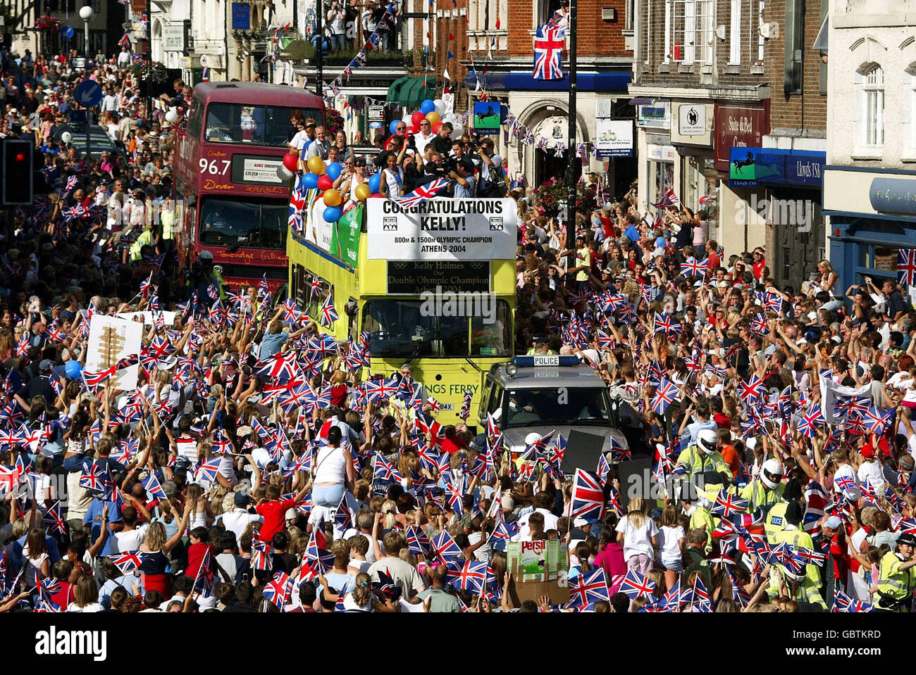 Kelly Holmes shows off her two Olympic gold medals from the top of an open-topped bus as thousands of people pack the streets of her home town, Tonbridge in Kent, to welcome her home from Athens Stock Photo