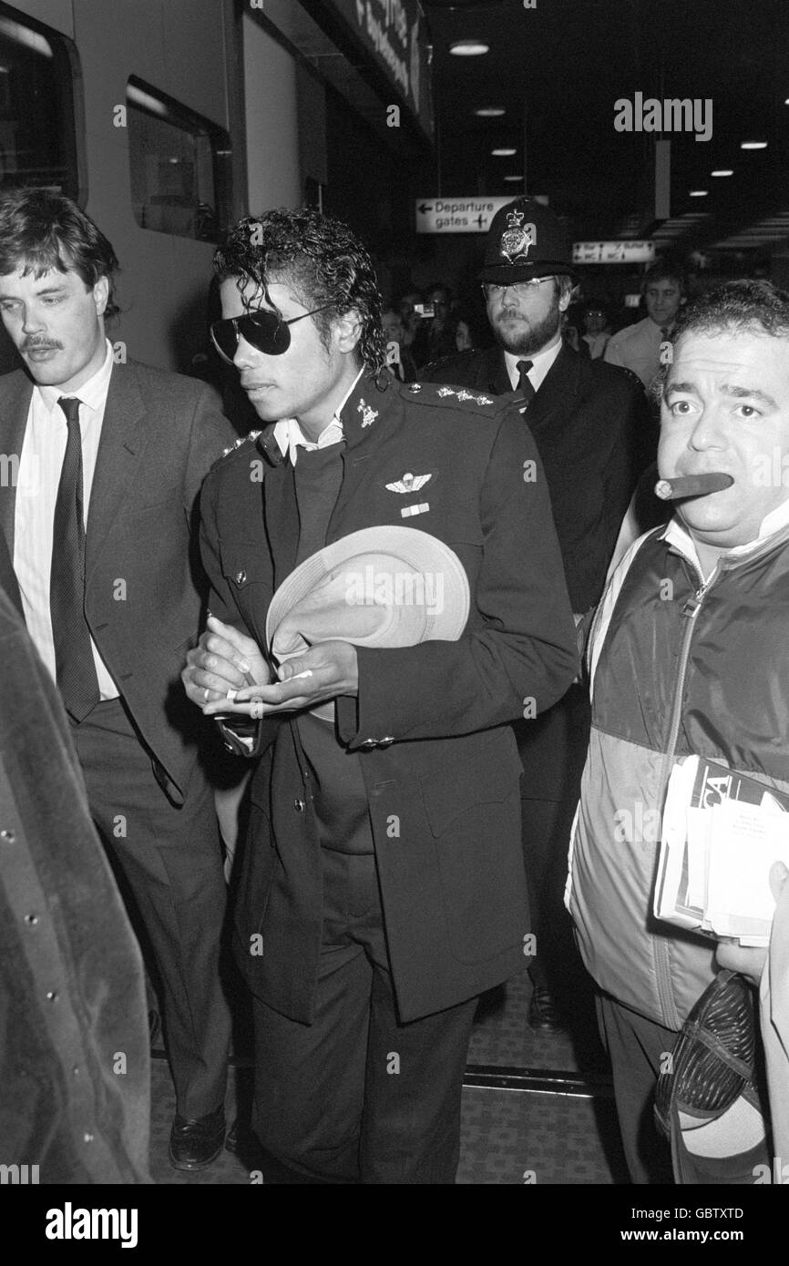 Pop star Michael Jackson leaves Heathrow Airport to fly to New York on Concorde after his short stay in Britain. To his right is his manager, Frank Dileo. Stock Photo