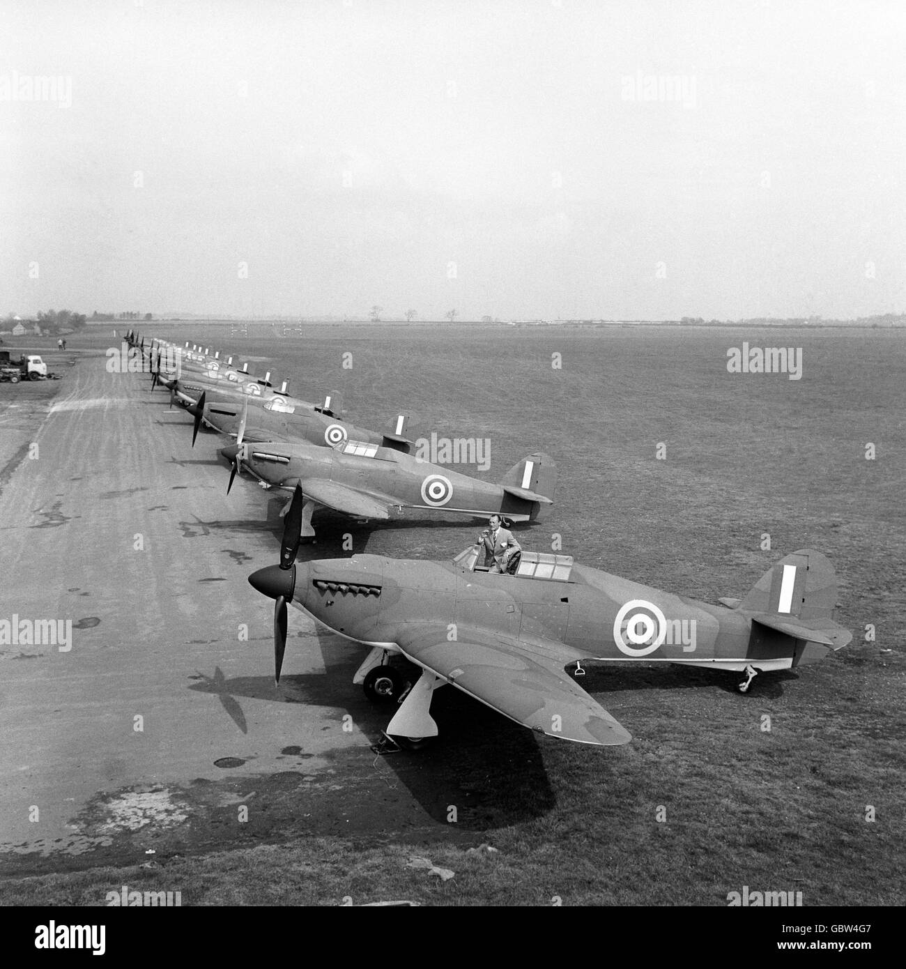 Nostalgic line-up of Hurricanes and Spitfires, the last-war fighters which won the Battle of Britain, at RAF Henlow, Bedfordshire, where they are being prepared to fight again for the film of the epic victory. Stock Photo