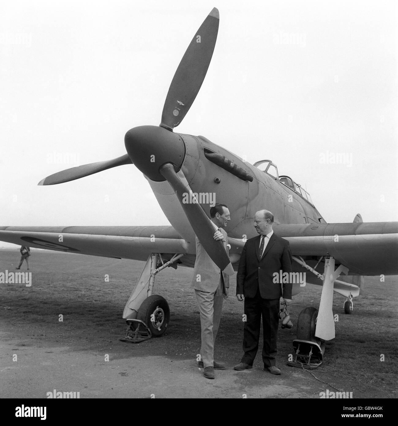 Flight Lt. James 'Ginger' Lacey, right, and Wing Commander Robert Stanford-Tuck stand next to a British Hurricane fighter at RAF Henlow, Buckinghamshire. The two veterans, along with many British and German aircraft from WWII, are part of the epic film being made both here and across Europe, 'The Battle of Britain' Stock Photo