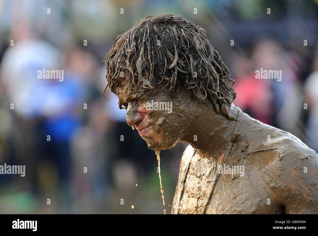 A festival goer covered in mud after wrestling with his friend at the 2009 Glastonbury Festival at Worthy Farm in Pilton, Somerset. Stock Photo