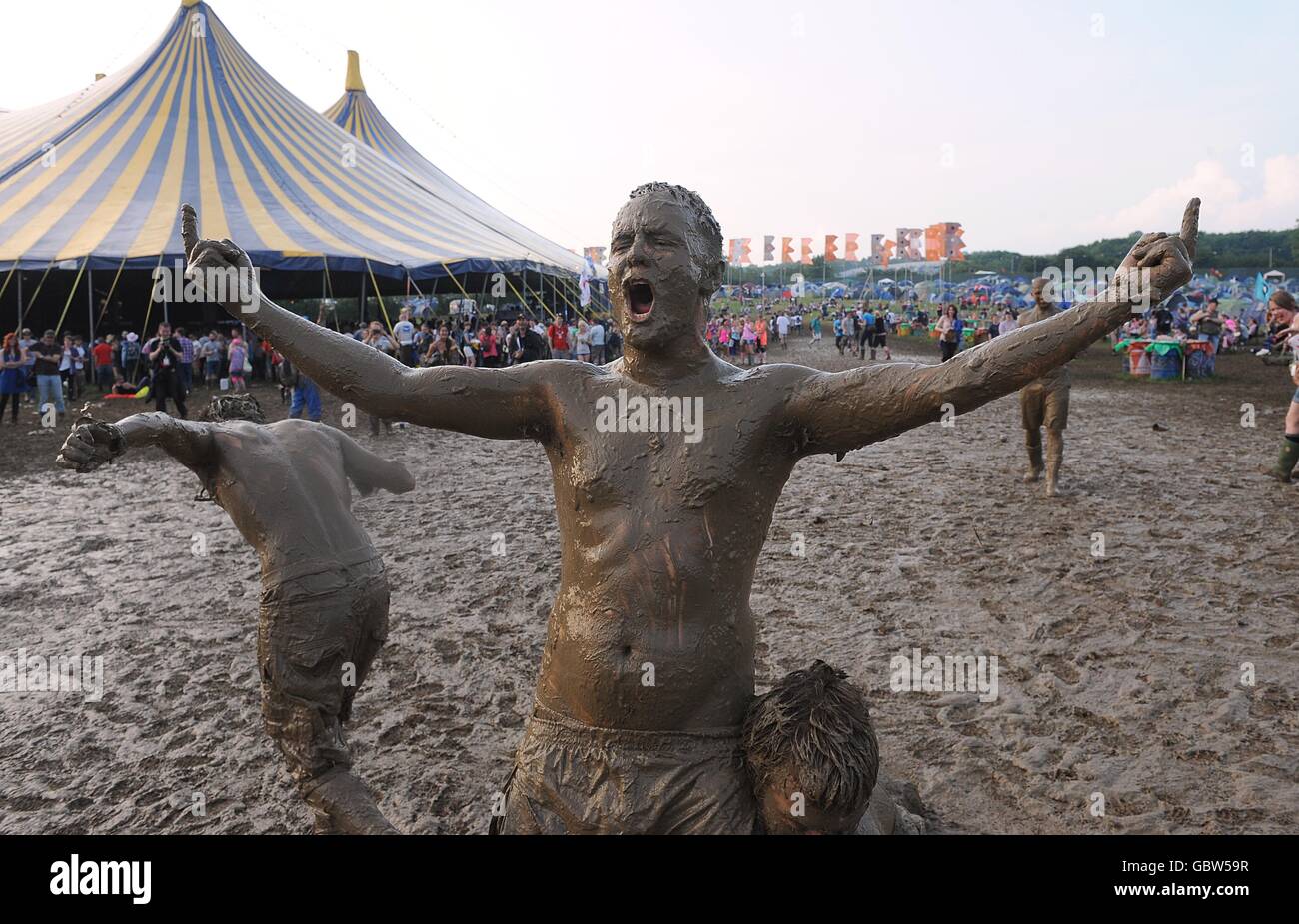 Festival goers covered in mud after a wrestling match during the 2009 Glastonbury Festival at Worthy Farm in Pilton, Somerset. Stock Photo