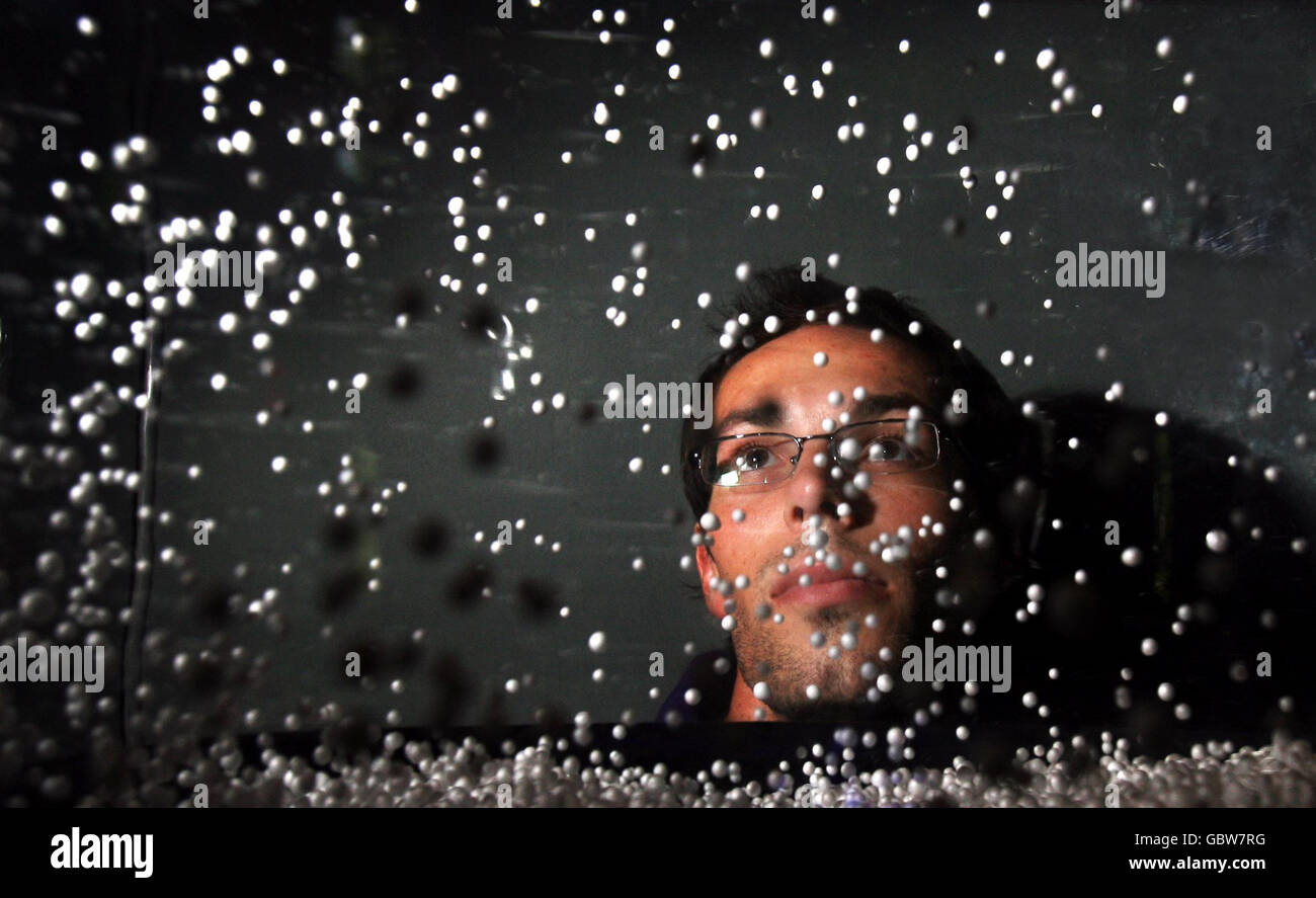 Durham University Astronomy PHD Student Alex Merson looks at the super nova explosion galaxy simulator at The Royal Society Summer Science Exhibition in London. Stock Photo