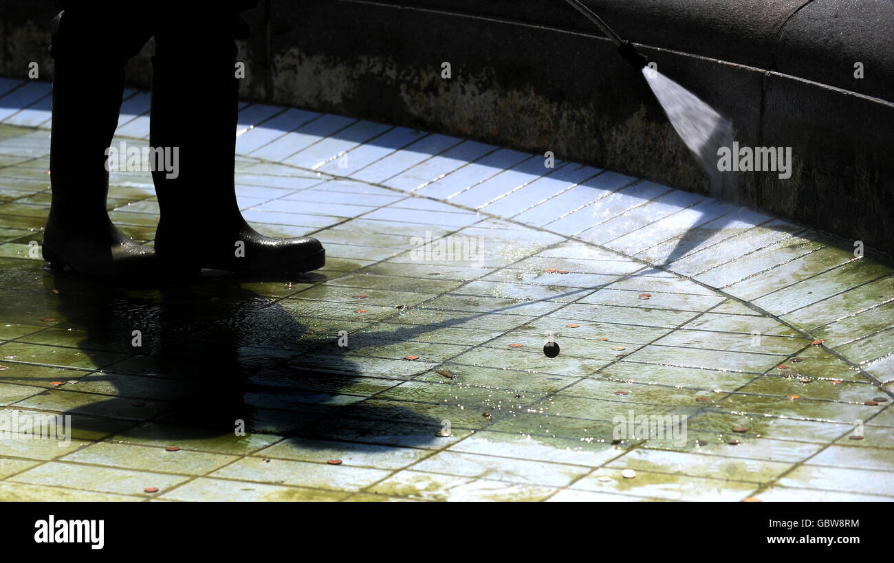 A worker clean algae from the fountains in Trafalgar Square, London