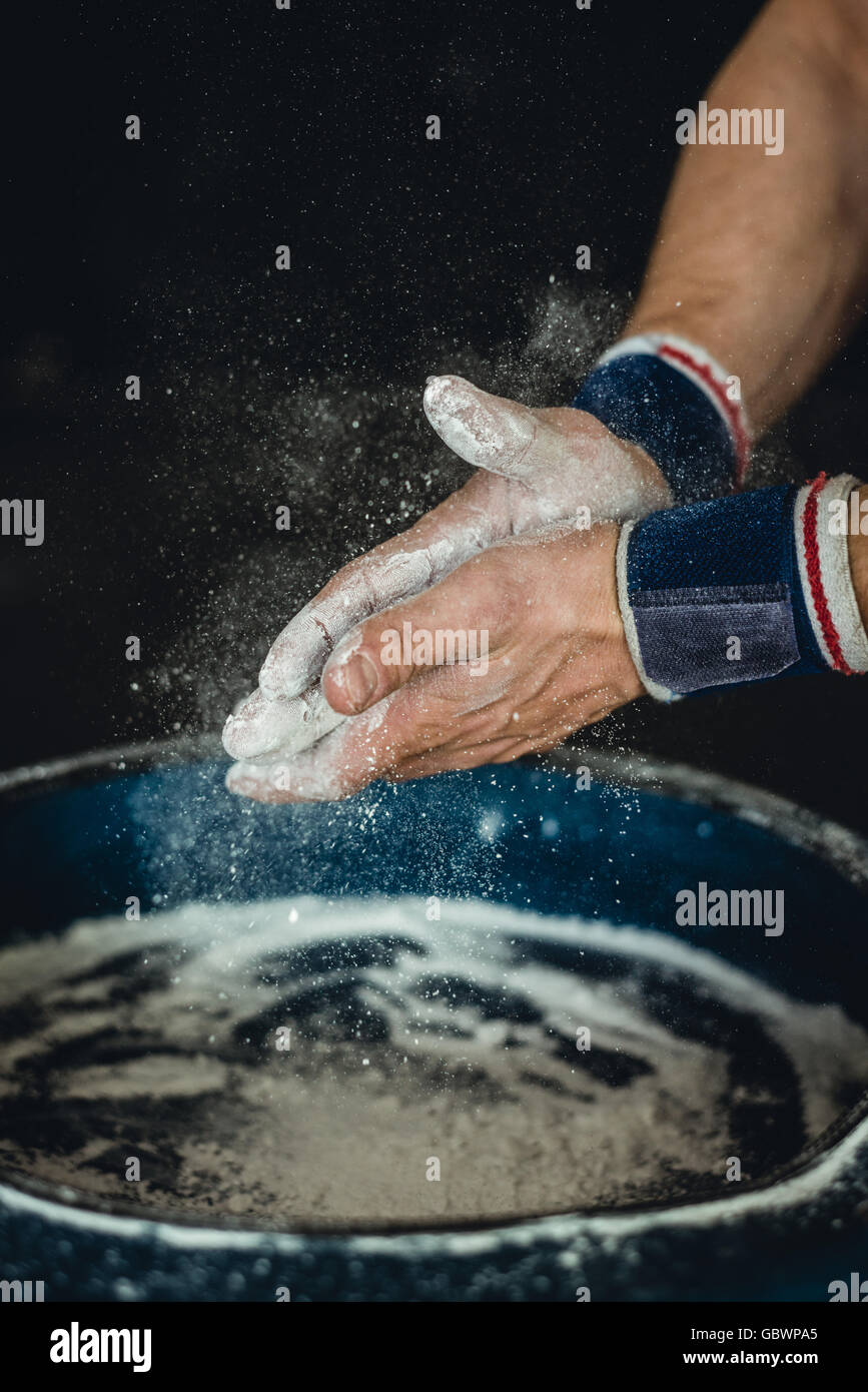 Preparing hands with chalk before beginning calisthenics, gymnastics fitness training Stock