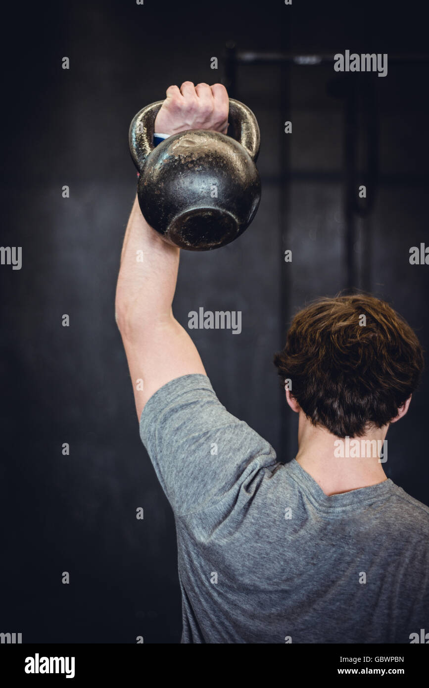 Man working out in gym with kettlebell. Stock Photo