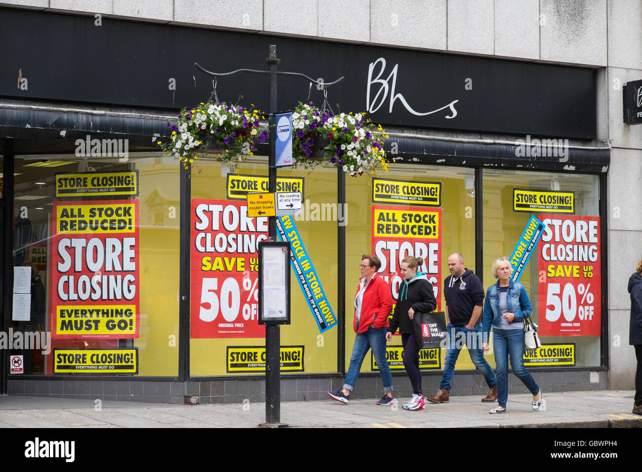 Shoppers passing British Home Stores shop in Truro, Cornwall with closing down sale notices in the windows. Stock Photo