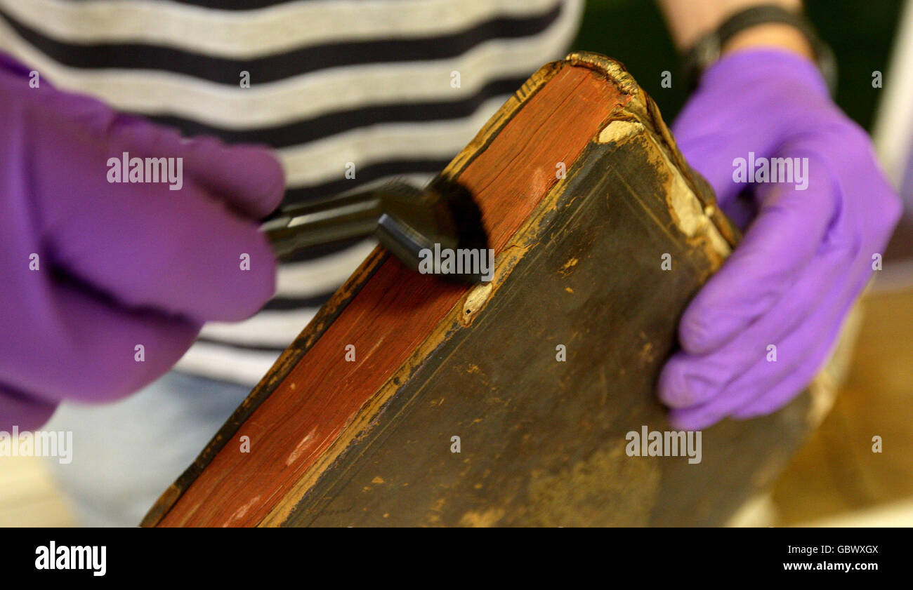 St Mary's Church library removal. One of the books from an entire Parish library at St Mary's Church in Nantwich, Cheshire, is cleaned. Stock Photo